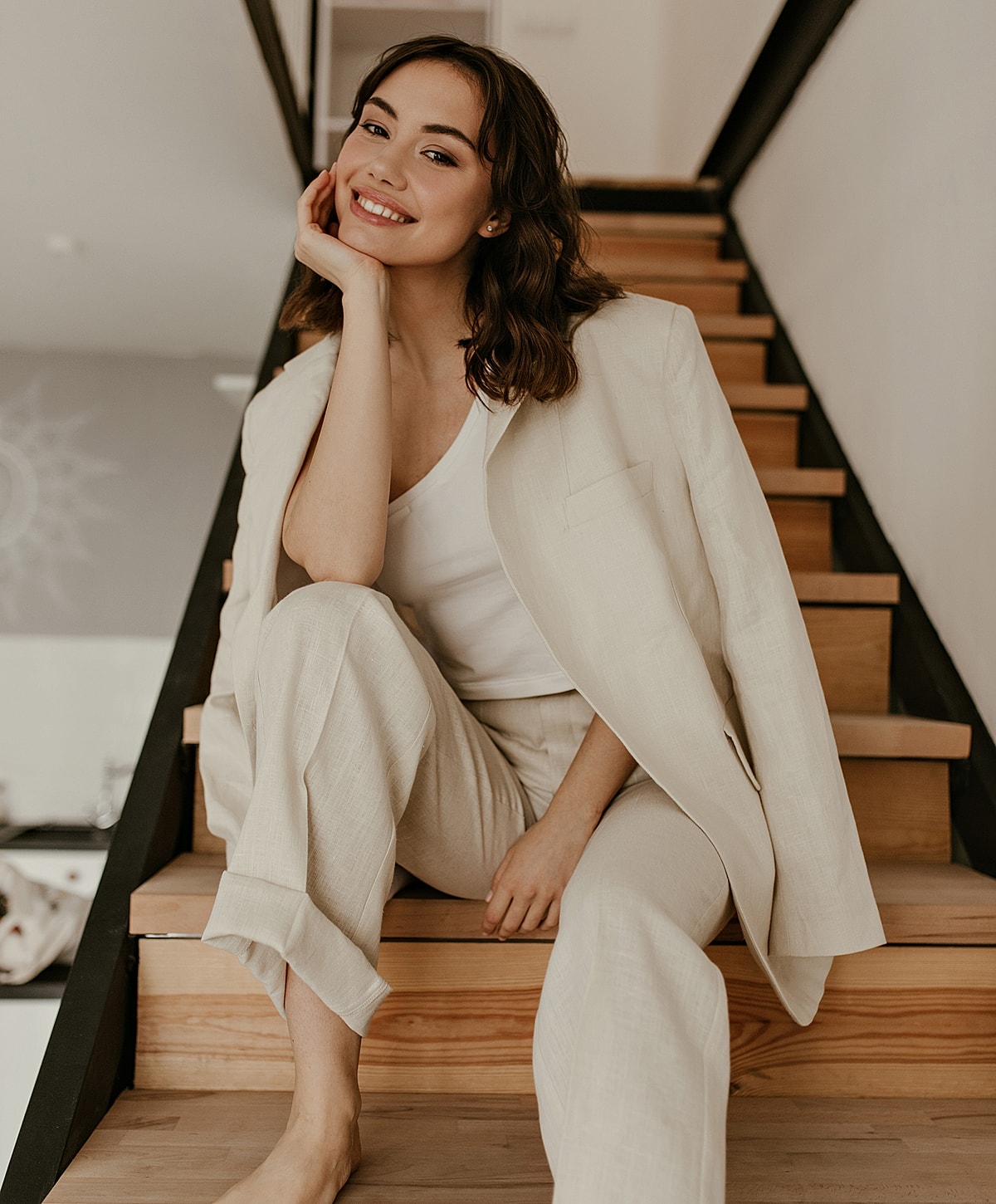 Woman in stylish outfit sitting on stairs.